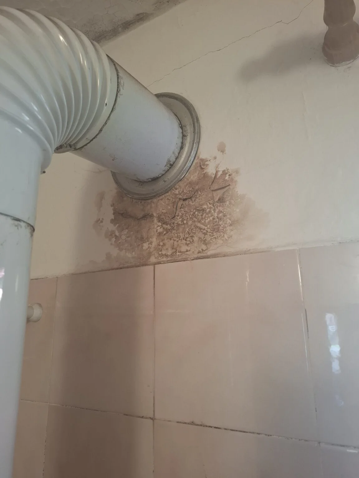 Oštećen zid s tragovima vlage i mrljama ispod dimovodne cijevi prije sanacije u Rijeci.